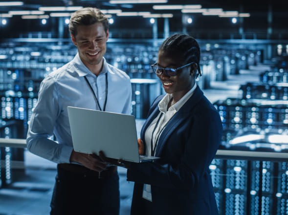 Man and woman standing and working on a laptop